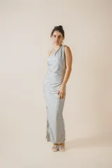 Vestido largo plateado de corte ajustado, con escote asimétrico, espalda descubierta y tajo lateral.