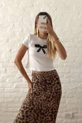 Remera blanca ajustada al cuerpo con estampado de moño de encaje negro en el centro.