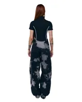 Pantalón unisex de denim 100% algodón con lavado overo (manchas grises sobre negro). Calce wide/relajado, tiro medio, pierna extra ancha y caída larga. Cintura con elásticos laterales, costuras curvas, bolsillos delanteros y traseros curvos, presillas para cinto, cierre y botón metálico.