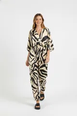 Mono largo con estampado animal print cebra en tonos beige y negro, con escote en V cruzado, mangas 3/4 amplias y cintura elastizada.