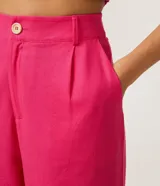 Conjunto de top y pantalón color fucsia. El top es corto, con tirantes finos y abertura en el centro. El pantalón es de corte palazzo, con cintura alta y bolsillos laterales.