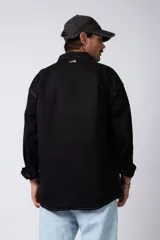 Camisa verde militar de manga larga, corte oversize, con cuello clásico, cierre frontal con botones y bolsillo en el pecho. Confeccionada en algodón suave y con costuras a la vista.