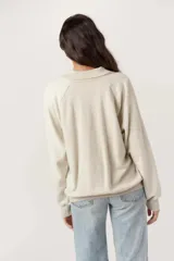 Pullover de tejido liso con mangas de fleece, cuello camisero con escote en V y puños y bajo acanalados.
