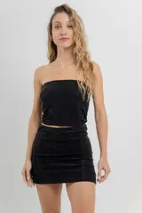 Minifalda negra ajustada al cuerpo, confeccionada en tejido elástico con strass plateado.