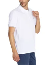 Chomba azul marino de piqué de algodón pima peruano, con cuello clásico, tapeta de dos botones blancos, mangas cortas con ribete rosa y logo de la marca bordado en el pecho.
