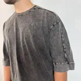 Remera gris con efecto lavado, corte oversize y mangas 3/4.