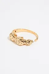 Pulsera rígida dorada con forma de pantera con manchas negras y pequeños cristales blancos incrustados.