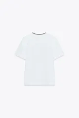 Camiseta blanca de algodón con cuello redondo y detalle de tricot a contraste en azul marino. Estampado frontal con texto "Estate sulla Costiera Amalfitana" en azul marino.