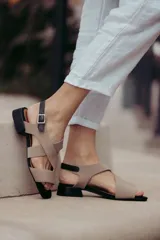 Sandalias de cuero color beige con tiras cruzadas y hebilla lateral. Taco cuadrado color marrón oscuro.