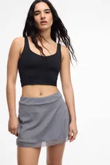 Short deportivo color lila con calza interna y bolsillo lateral. Presenta un frente cruzado y detalle de microtul.