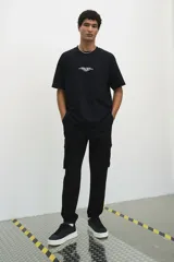 Pantalón jogger negro de felpa pesada de mezcla de algodón, corte slim fit, con cintura elástica ajustable con cordón, cierre decorativo, bolsillos al bies, bolsillo trasero y bolsillos cargo con solapa y botones a presión ocultos en las piernas.
