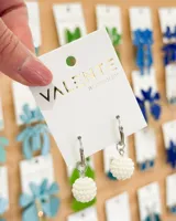 Aros colgantes con aro de acero plateado y dije de bola de perlas sintéticas color crema.