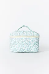 Necesser de viaje acolchado con estampado floral en tonos celestes y blancos. Posee cierre perimetral y asa superior para transporte.