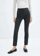 Pantalón de vestir gris oscuro, de corte skinny, tiro medio, con bolsillos laterales y traseros.