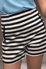 Bermuda de tiro alto con estampado de rayas horizontales en blanco y azul marino. Tiene bolsillos delanteros de vivo y cierre lateral con cremallera oculta en la costura.