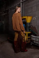 Sweater tejido de lana color marrón con bordado de un jinete a caballo. Tiene cuello redondo y puños acanalados.