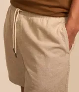 Bermuda masculina color crema, de tejido con textura sutil, cintura elástica con cordón de ajuste y bolsillos laterales.