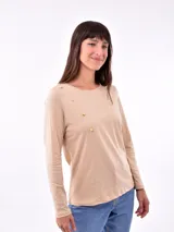 Remera manga larga color lila con cuello redondo y detalle de botones dorados en el hombro.