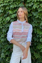 Blusa rosada con mangas largas, cuello con volados y estampado de líneas verticales.