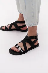 Sandalias negras con tiras cruzadas de cuero y pelo vacuno con estampado animal print.
