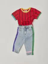 Pantalón de jean celeste con efecto lavado, corte recto y largo a la rodilla. Presenta una cinta vertical color violeta en la pierna izquierda, una cinta vertical color verde en la pierna derecha y una cinta horizontal color rosa en la parte inferior de ambas piernas.