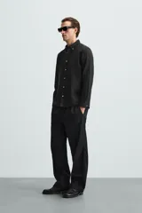 Camisa celeste a rayas verticales, de corte relaxed fit, confeccionada en lino y algodón. Tiene cuello abotonado, manga larga con puños abotonados, bolsillo de parche en el pecho y cierre frontal con botones.