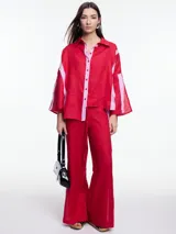 Pantalón de lino negro con elástico en la cintura, tiro medio y calce relajado. Lleva tiras en color gris aplicadas a los laterales, que quedan sueltas en la parte inferior y pueden anudarse.