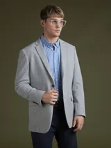 Blazer azul marino de corte clásico, con solapas de muesca, cierre de dos botones y bolsillos de parche.