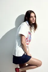 Remera blanca de algodón con cuello redondo y mangas cortas. Estampado frontal con diseño de lata de sardinas con texto en francés y detalles en rojo y azul.
