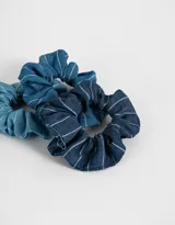 Set de tres scrunchies de tela de denim en diferentes tonos de azul con rayas blancas.