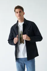 Sobrecamisa azul marino de algodón grueso, con cuello clásico, cierre frontal con botones, dos bolsillos de parche en el pecho y dos bolsillos laterales.