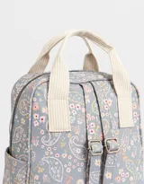 Mochila negra de cuerina con doble asa corta de mano con textura, correas regulables, cierre superior, bolsillo frontal con cierre, bolsillos laterales y tag en relieve.