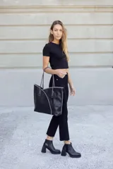 Botinetas negras de cuero con caña baja, cierre lateral y detalle de cuero texturizado en el talón. Taco geométrico y punta cuadrada.