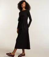Vestido midi negro de rib con viscosa certificada, corte ajustado, escote U, manga larga, espalda abierta y pliegues.
