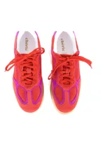 Championes de cuero vacuno color rojo con detalles en fucsia, suela color caramelo y cordones rojos.