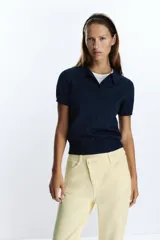 Jeans tobilleros de tiro alto color blanco, corte recto y cinco bolsillos. Cierre frontal cruzado con cremallera y botones.