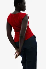 Top entallado rojo en punto con textura. Modelo con escote bote, manga japonesa y costuras laterales fruncidas para un efecto drapeado suave.
