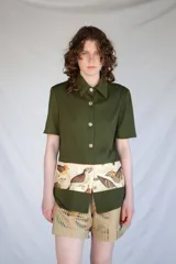 Camisa verde militar de manga corta con botones nacarados y corte estampado en el delantero con diseño de aves.