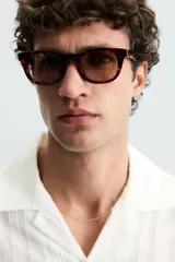 Camisa de calce relajado confeccionada en tejido jacquard de mezcla de algodón y viscosa. Presenta cuello bowling, manga corta, aberturas laterales en el bajo y cierre frontal con botones.