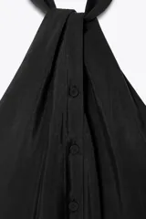 Top chaleco negro con cuello halter y cierre frontal con botones forrados.