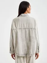 Chaqueta denim gris con botones en la delantera y dos bolsillos sin solapa tambien en el frente. Cuello camisero.