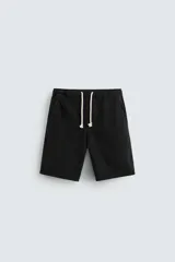 Bermuda relaxed fit confeccionada en denim de algodón, color negro. Cintura elástica ajustable con cordón. Bolsillos frontales y detalle de bolsillos traseros de vivo.