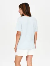 Remera color salmón con estampado de flor blanca y texto "Venice California".