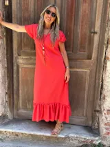 Vestido midi de seda color rojo, con escote en V, mangas cortas con volados y un amplio volado en el ruedo.