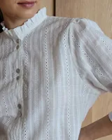 Camisa blanca de mangas 3/4 con cuello mao y botones frontales.