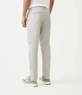 Pantalón de vestir color marrón, de corte slim y largo cropped. Confeccionado en tejido de algodón liso, con bolsillos laterales y traseros. Cierre frontal con botón y cremallera.