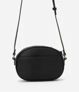 Bolso camera bag pequeño de poliuretano color negro, con forma redondeada, correa ajustable, bolsillo delantero y cierre superior.