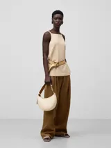 Bolso de hombro tipo baguette color crema, con textura granulada y asa corta regulable.