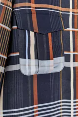 Camisa de mujer confeccionada en viscosa con estampado a cuadros en tonos azul, naranja, blanco y amarillo. Tiene cuello mao, manga larga con puños plisados, dos bolsillos de parche con solapa en el pecho, bajo recto y cierre frontal con botones ocultos.