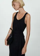 Vestido midi negro de tejido fluido con tirantes anchos, cuello escotado y detalle de nudo.